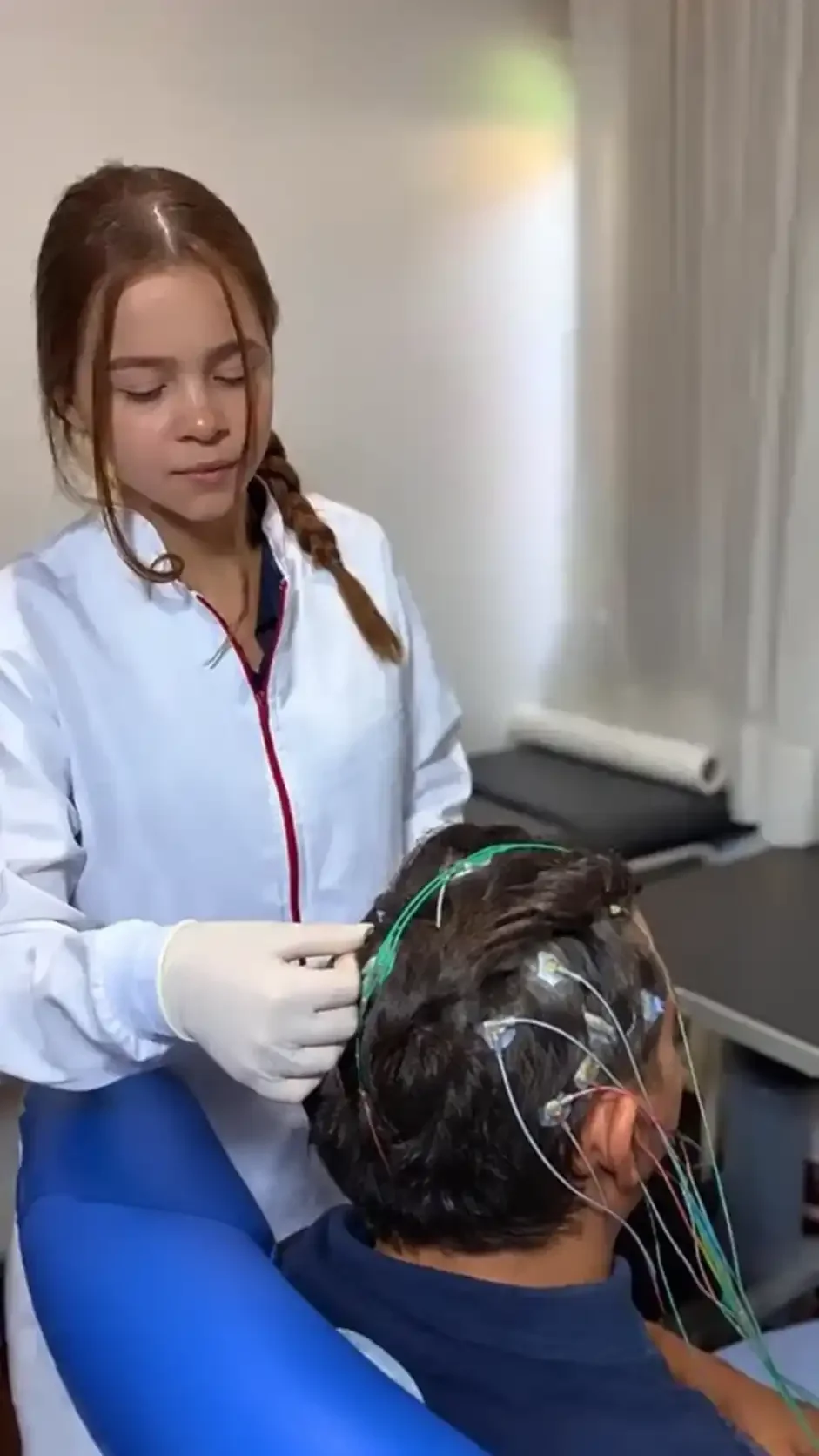 Profissional posicionando eletrodos na cabeça de um paciente durante atendimento na RAD